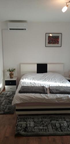 比哈奇的住宿－Apartment Beha，卧室配有一张白色墙壁的床