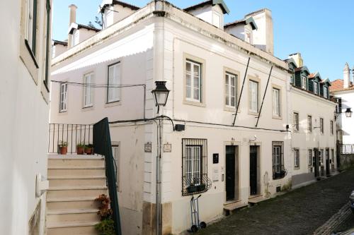 een wit gebouw met trappen op een straat bij Casa da Pendoa in Sintra