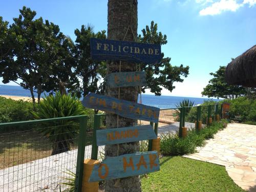 a pole with street signs on a tree at O Costão do Sol in Balneário Camboriú