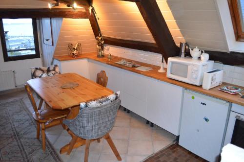 - une cuisine avec une table et un four micro-ondes dans l'établissement Appartement vue mer Granville, à Granville