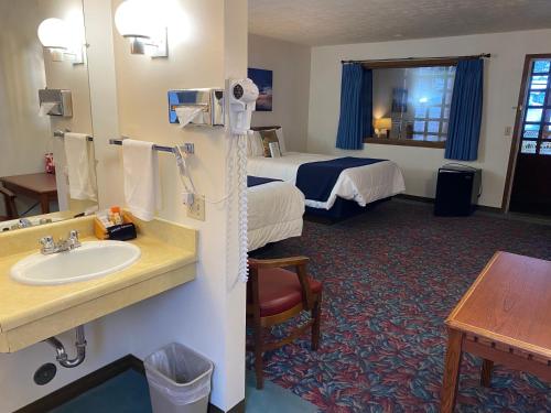 Habitación de hotel con lavabo y cama en Cedar Motor Inn, en Marquette