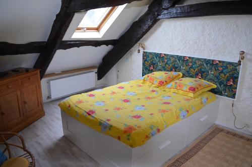 - une chambre avec un lit doté d'une couette et d'oreillers jaunes dans l'établissement Appartement vue mer Granville, à Granville