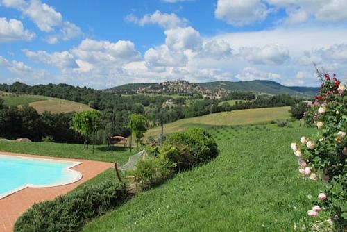 a garden with a swimming pool in a grassy field at Agriturismo Gattogiallo in Montegabbione