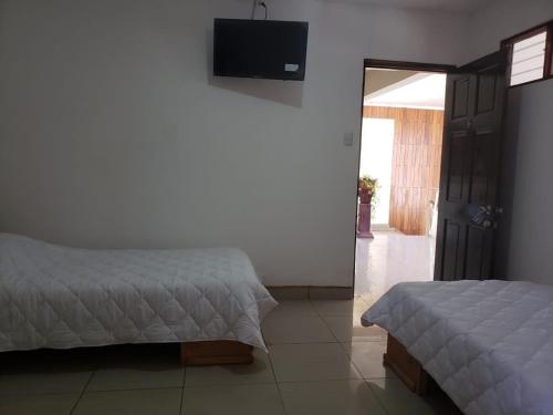 a bedroom with two beds and a flat screen tv at HOTEL TERRAZAS BOUTIQUE in Los Yoses