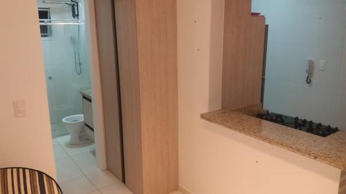 a bathroom with a shower and a toilet and a phone at Praia Grande - Edifício Frente ao Mar in Praia Grande