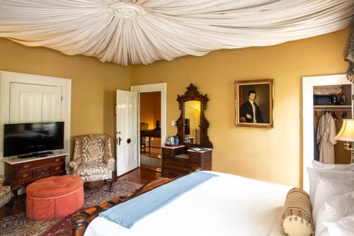 een slaapkamer met een bed en een kroonluchter bij Eliza Thompson House, Historic Inns of Savannah Collection in Savannah