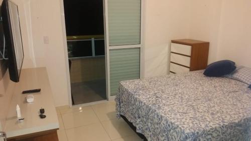 a bedroom with a bed and a sliding glass door at Praia Grande - Edifício Frente ao Mar in Praia Grande
