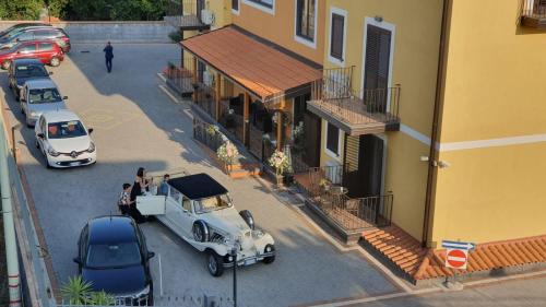 een oude auto geparkeerd op een parkeerplaats naast een gebouw bij I Colori dell'Etna in San Giovanni la Punta