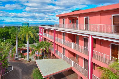 an aerial view of a pink building with palm trees at Hotel RDG in Managua