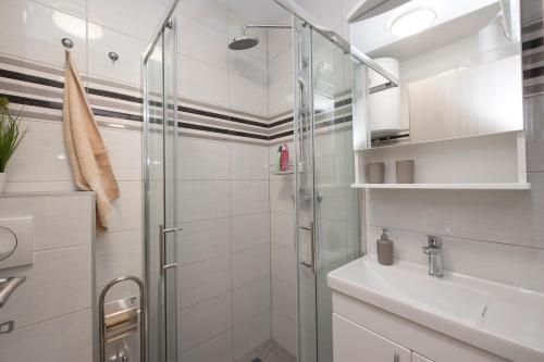 une salle de bain avec douche et lavabo dans l'établissement Apartments Maraton, à Split