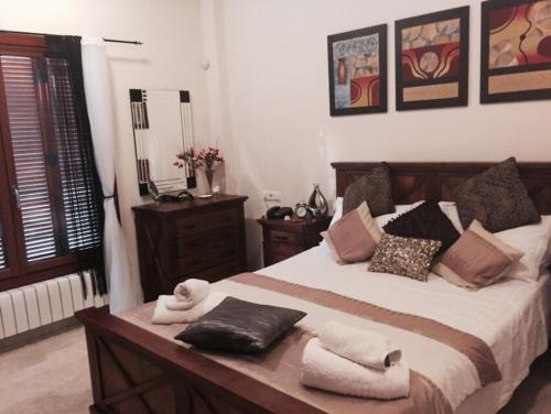 a bedroom with a large bed with towels on it at Casa Catherina Joan - El Valle Golf Resort in Baños y Mendigo
