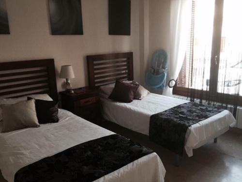 1 dormitorio con 2 camas y ventana en Casa Catherina Joan - El Valle Golf Resort, en Baños y Mendigo