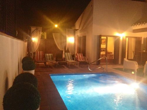 a large swimming pool in a living room at night at Casa Catherina Joan - El Valle Golf Resort in Baños y Mendigo