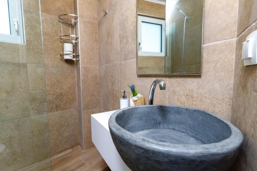 a bathroom with a large stone sink and a mirror at Georgioupoli Studio 2 with a pool and lake views in Georgioupoli