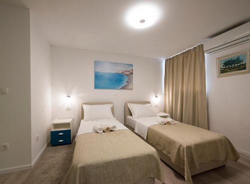 um quarto de hotel com duas camas com bichos de peluche em Apartments Maraton em Split