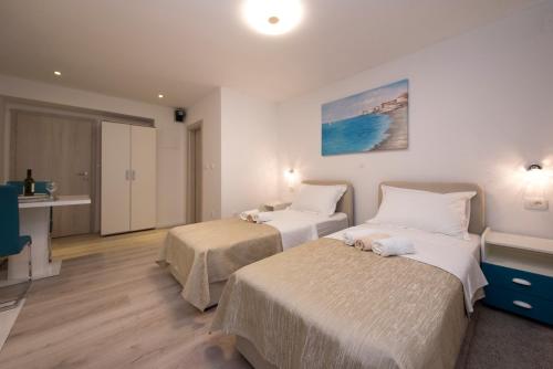 une chambre d'hôtel avec deux lits et une cuisine dans l'établissement Apartments Maraton, à Split