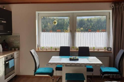 a dining room with a table and chairs and a window at Mia Apartman, Eisenerz in Eisenerz