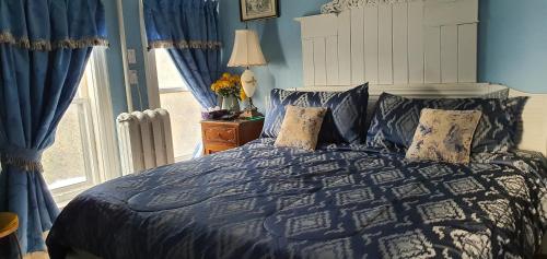 a bed with a blue comforter and pillows on it at A Moment in Time Bed and Breakfast in Niagara Falls