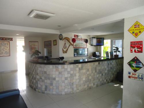 un restaurante con bar de azulejos en una habitación en Hotel Des Basques, en Maceió