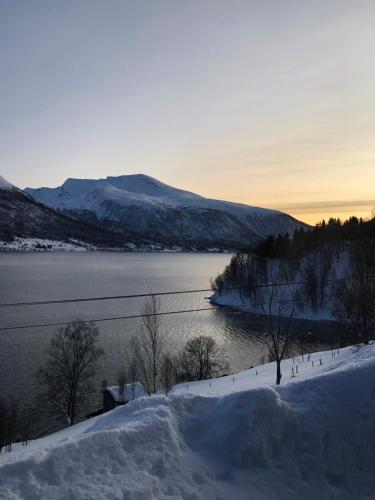 a view of a body of water with snow and mountains at Hundbergan apartment-free parking-15 min from Tromsø in Trondalen