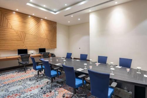 a conference room with a large table and blue chairs at Radisson Blu Resort Jizan in Jazan