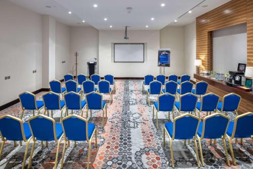 a conference room with blue chairs and a podium at Radisson Blu Resort Jizan in Jazan