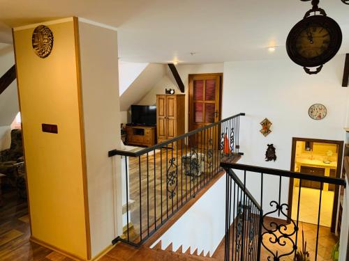 a staircase in a house with a clock on the wall at Penzion Na Růžku in Sedlčany