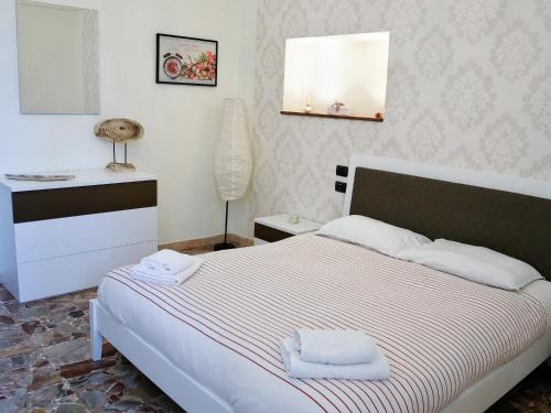 una camera da letto con un letto e due asciugamani di La Casetta di Nonna Pina - Appartamento con cucina in pieno centro a Torre Annunziata