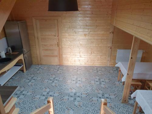 a room with a kitchen with a table and a refrigerator at Newland Wójtowicz in Debrznica