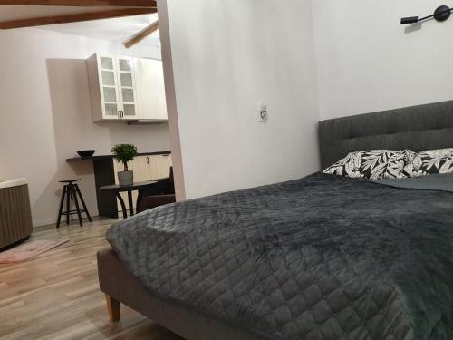 Un dormitorio con una cama y una mesa. en Apartamentai su Jacuzzi, en Panevėžys