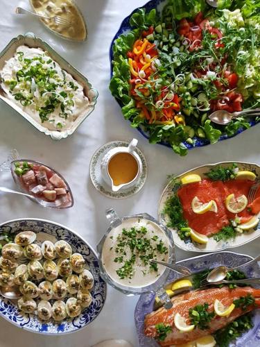 un tavolo apparecchiato con piatti di cibo e un'insalata di Cirkus Hostel Holken a Inkoo