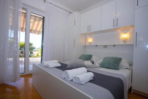 a white room with a bed with towels on it at VILLA MILENKA - Apartmani Gorana in Tučepi