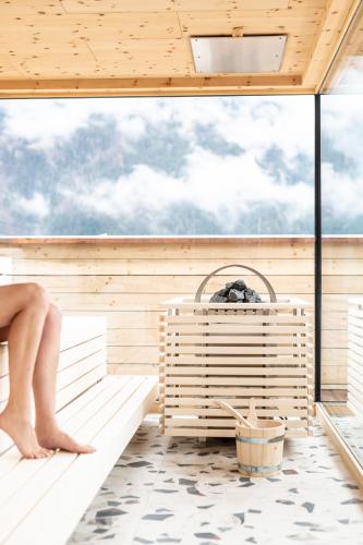 a woman is sitting in a sauna at Mari Pop Hotel in Ried im Zillertal