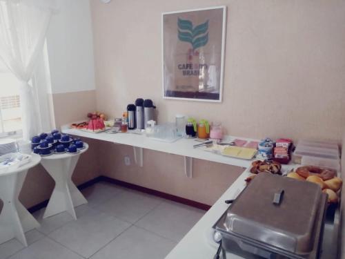 Hotel Centenario Itajuba في إيتاجوبا: مطبخ مع كونتر عليه الطاسات الزرقاء