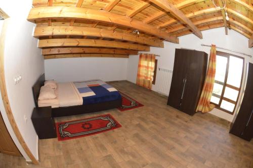 una camera con un letto in una stanza con soffitto in legno di Villa SALAM a Ifrane