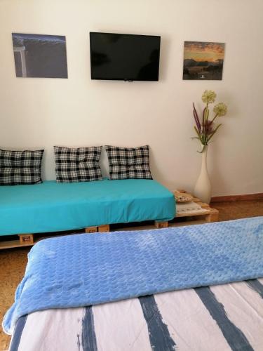 a living room with a couch and a flat screen tv at Casa do Mar - Nazaré in Nazaré
