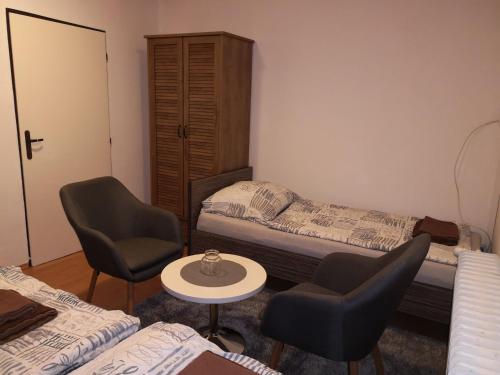 a bedroom with two beds and two chairs and a table at Penzion Zázrifka in Zázrivá
