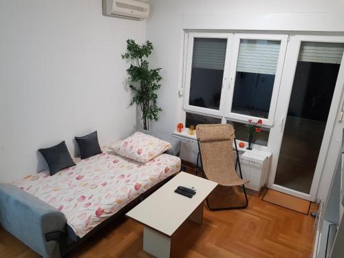 a small bedroom with a bed and a table at Lav apartments in Banja Luka