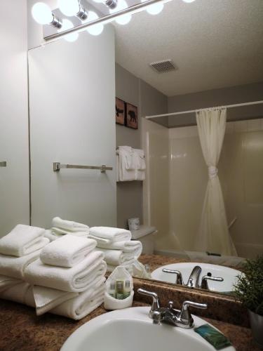a bathroom with a sink and a mirror and towels at Canadian Rockies Chalets by Trilink - 2 & 3 Bedroom Condos - Self Check-In - Walking Distance to Downtown - Free Parking - Pet-Friendly - No AC in Canmore