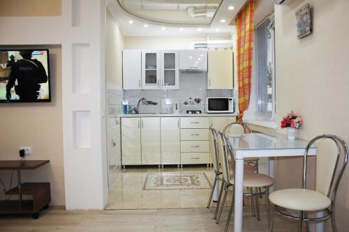 a kitchen with white cabinets and a table and chairs at Apartment in the center of Bender in Bender