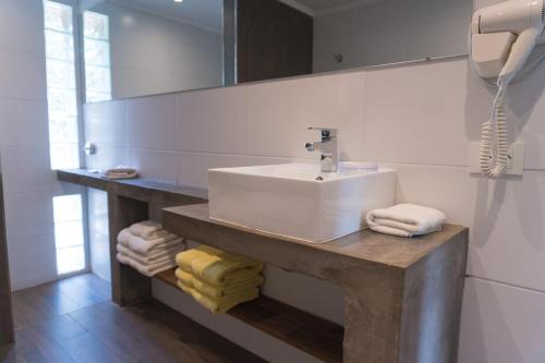 uma casa de banho com lavatório, espelho e toalhas em Brisas Serranas em Tandil