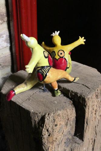 two toy figures sitting on top of a wooden stump at Meschermolen in Mesch