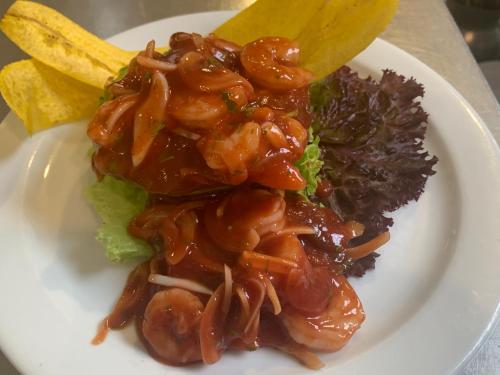 a white plate of food with meat and vegetables at La Masia Hotel Boutique in Anapoima