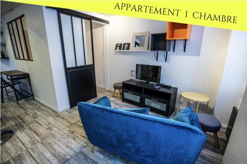a living room with a blue couch and a tv at Les Appartements du Pont Joubert in Poitiers