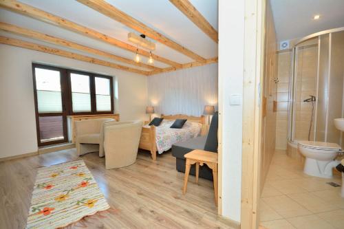 a room with a bedroom and a bed and a bathroom at Apartamenty i Pokoje Bacówka Centrum in Zakopane