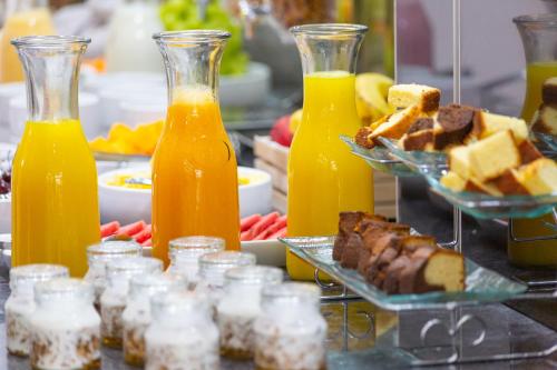a buffet with bottles of orange juice and desserts at Howard Johnson by Wyndham Lima Miraflores Art House in Lima