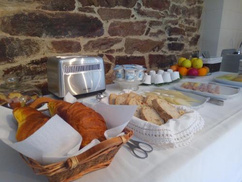 a table with a bunch of bread and a toaster at Bairro do Casal - Turismo d'Aldeia in Vila Nova de Foz Coa