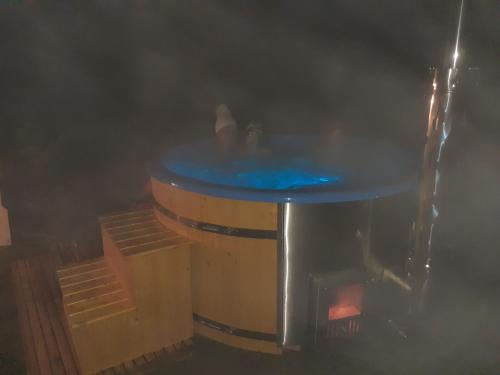 a hot tub in a barrel with people in it at Dereniowe Wzgórze in Sejny