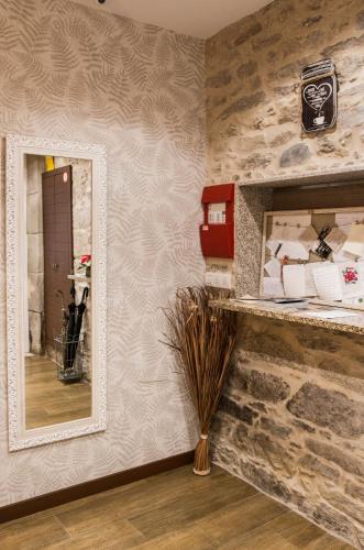 a mirror in a room with a stone wall at Casa da Balconada in Santiago de Compostela