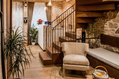 een woonkamer met een stoel en een trap bij Casa da Balconada in Santiago de Compostela